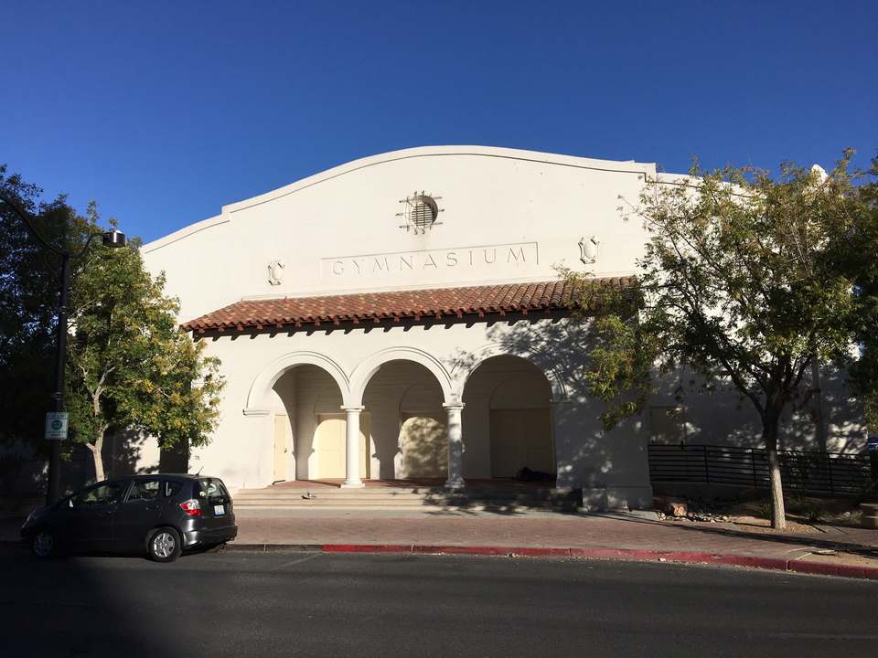 White mission style school building with three arches and a red tile roof